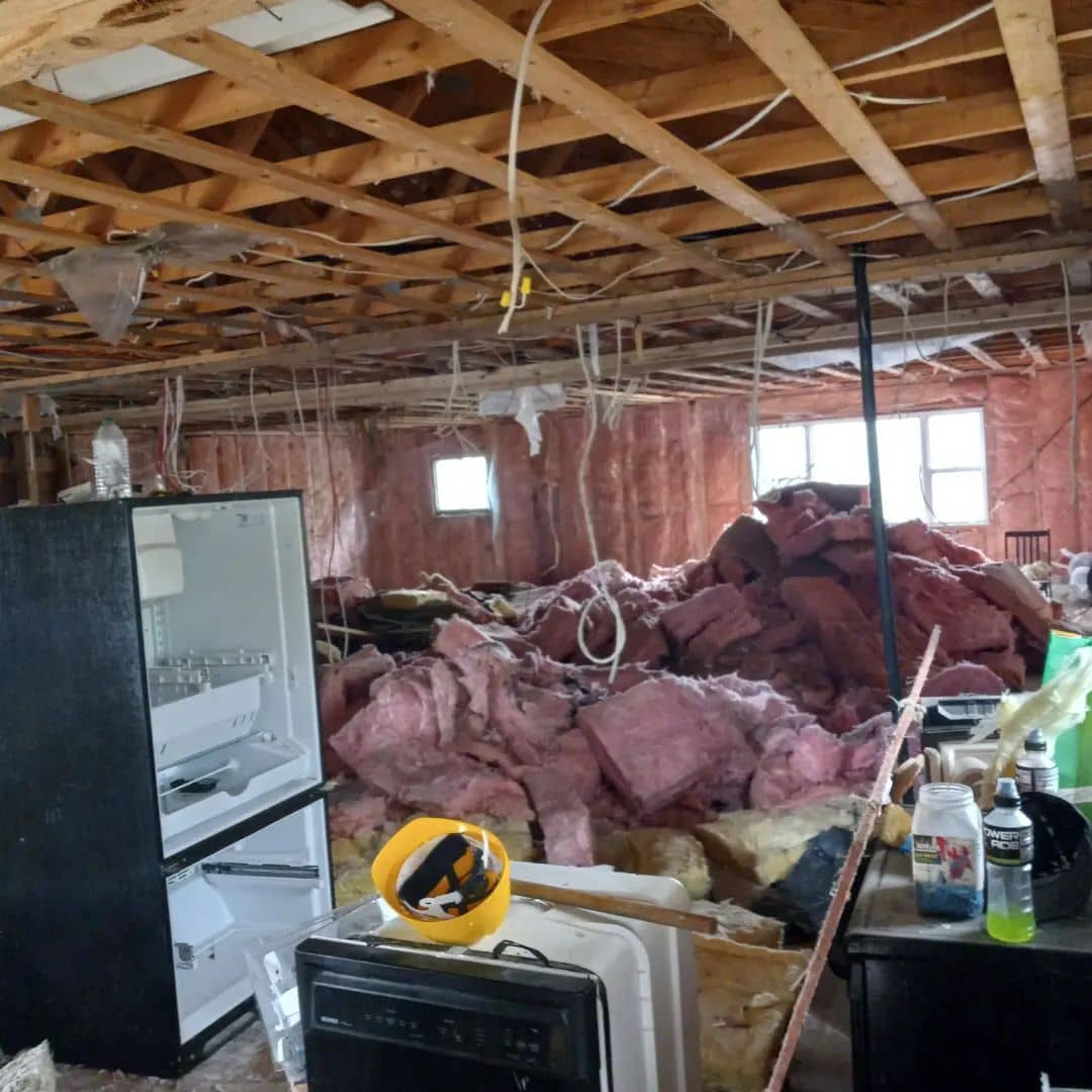 Interior demolition in progress with exposed insulation and scattered debris. Demonstrates the benefits of hiring an interior demolition contractor.